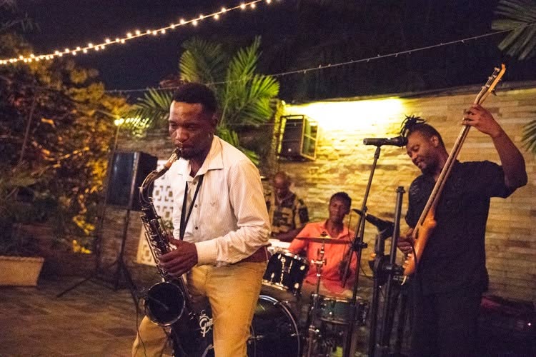 Saxophonist performing with rhythm section in a garden venue