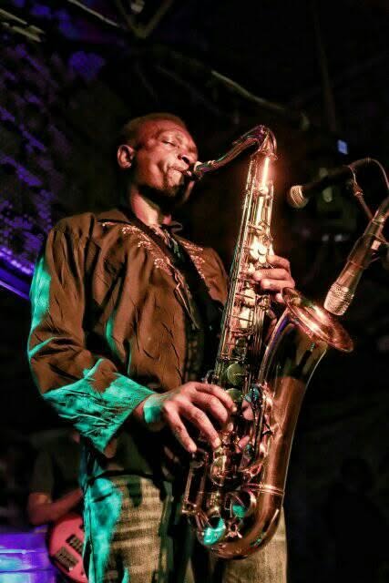 Juma Tutu playing saxophone on a night stage